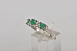A 14CT WHITE GOLD EMERALD AND DIAMOND RING, designed with three circular cut emeralds, interspaced