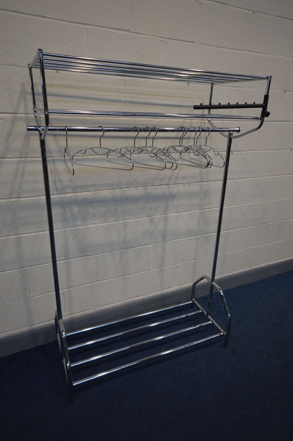 A CHROME CLOTHES RAIL with shelves and metal hangers, length 120cm x depth 50cm x height 176cm