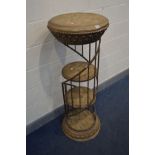 A CYLINDRICAL RESIN DISPLAY STAND, with a wrought iron gallery spiralling around three tier shelves,