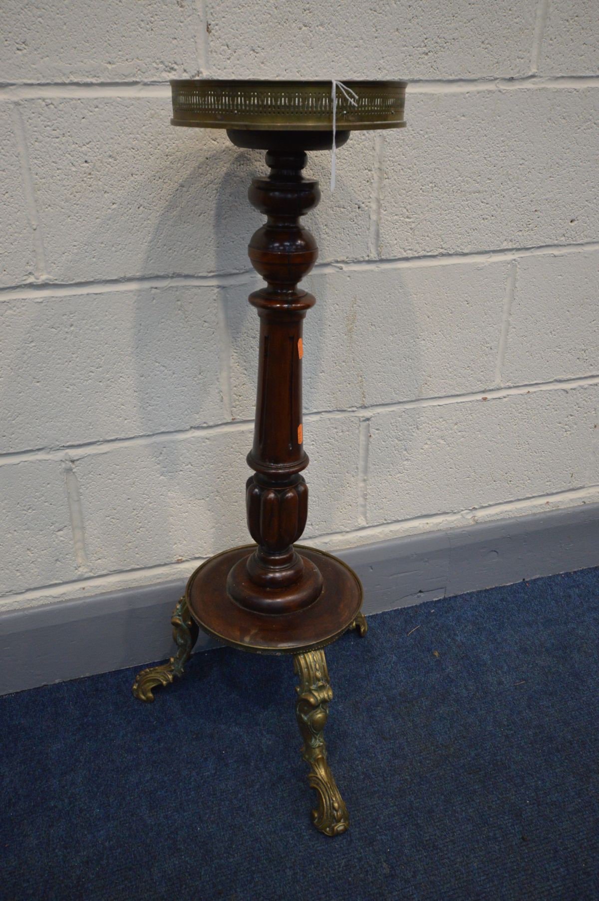 A MAHOGANY TORCHERE STAND, with a brass pierced gallery above a circular top, on turned and fluted