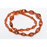AN AMBER COLOURED BAKELITE BEAD NECKLACE, graduated twist style beads interspaced with round