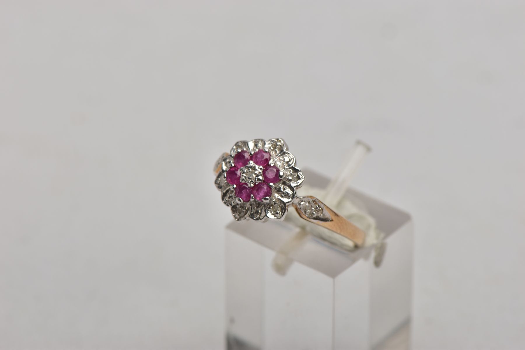 A 9CT GOLD RUBY AND DIAMOND CLUSTER RING, the three tier cluster set with a central single cut