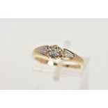 A 9CT GOLD DIAMOND RING, designed with an illusion set round brilliant cut diamond, flanked with