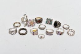 A BAG OF SILVER AND WHITE METAL RINGS, to include a large silver cluster ring, set with white,