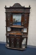 A 19TH CENTURY HEAVILY CARVED OAK HALL STAND, with a pediment and finials to top, a central bevel