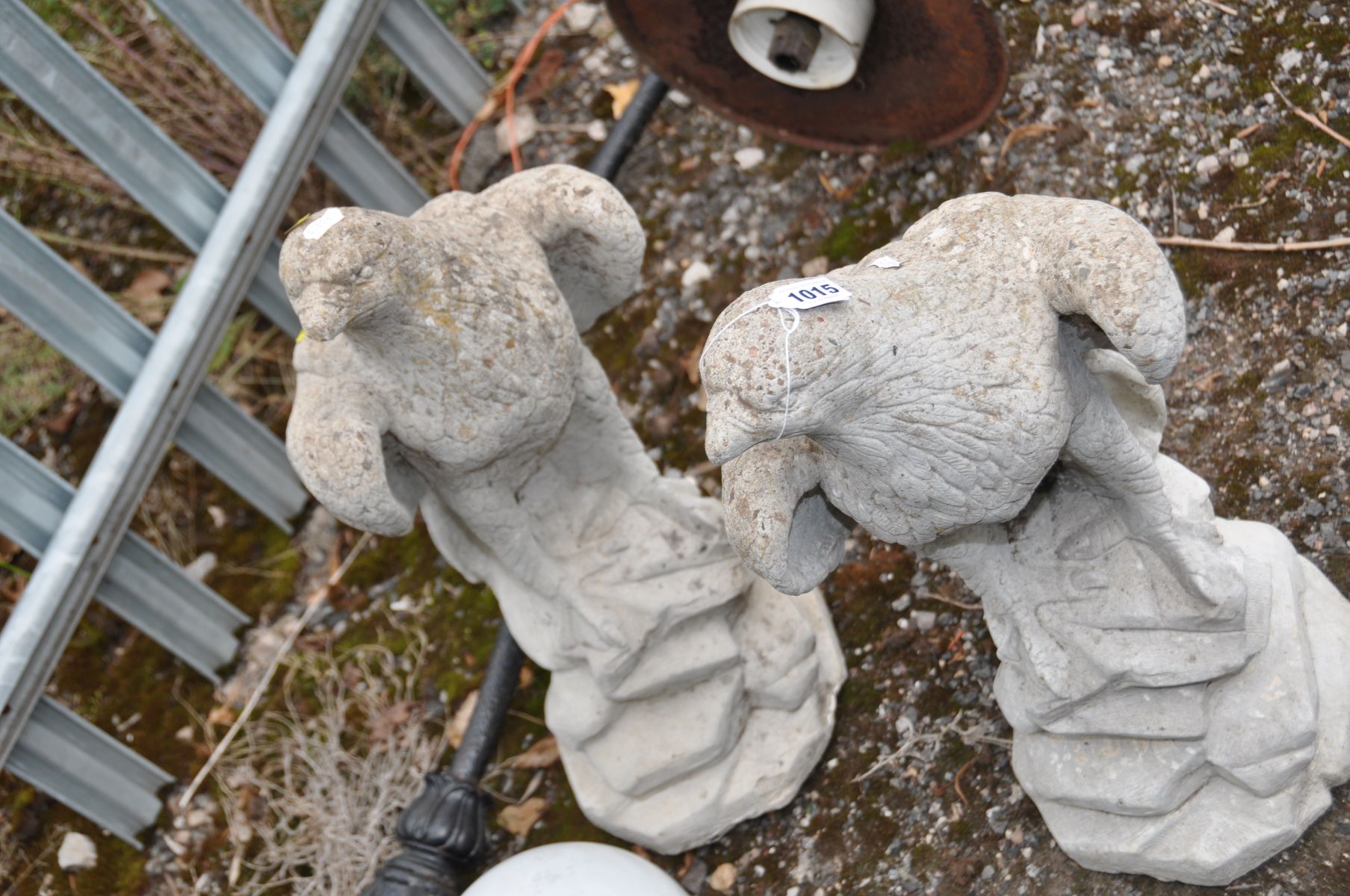 A PAIR OF COMPOSITE GARDEN FIGURES in the form of Eagles standing on a craggy rock 62cm high