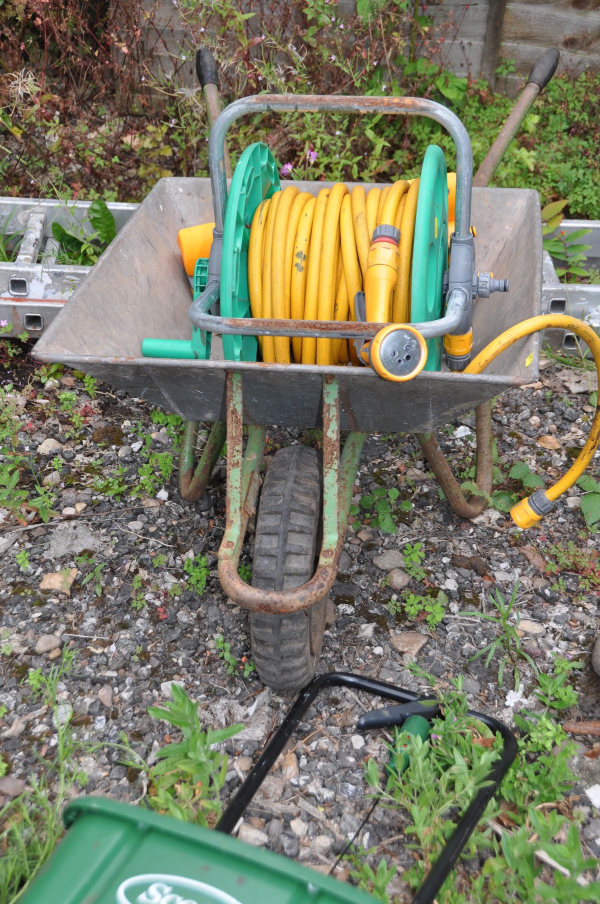 A QUANTITY OF GARDEN TOOLS AND A WHEELBARROW including spades, rakes, seed spreaders, hosepipe on - Image 3 of 3