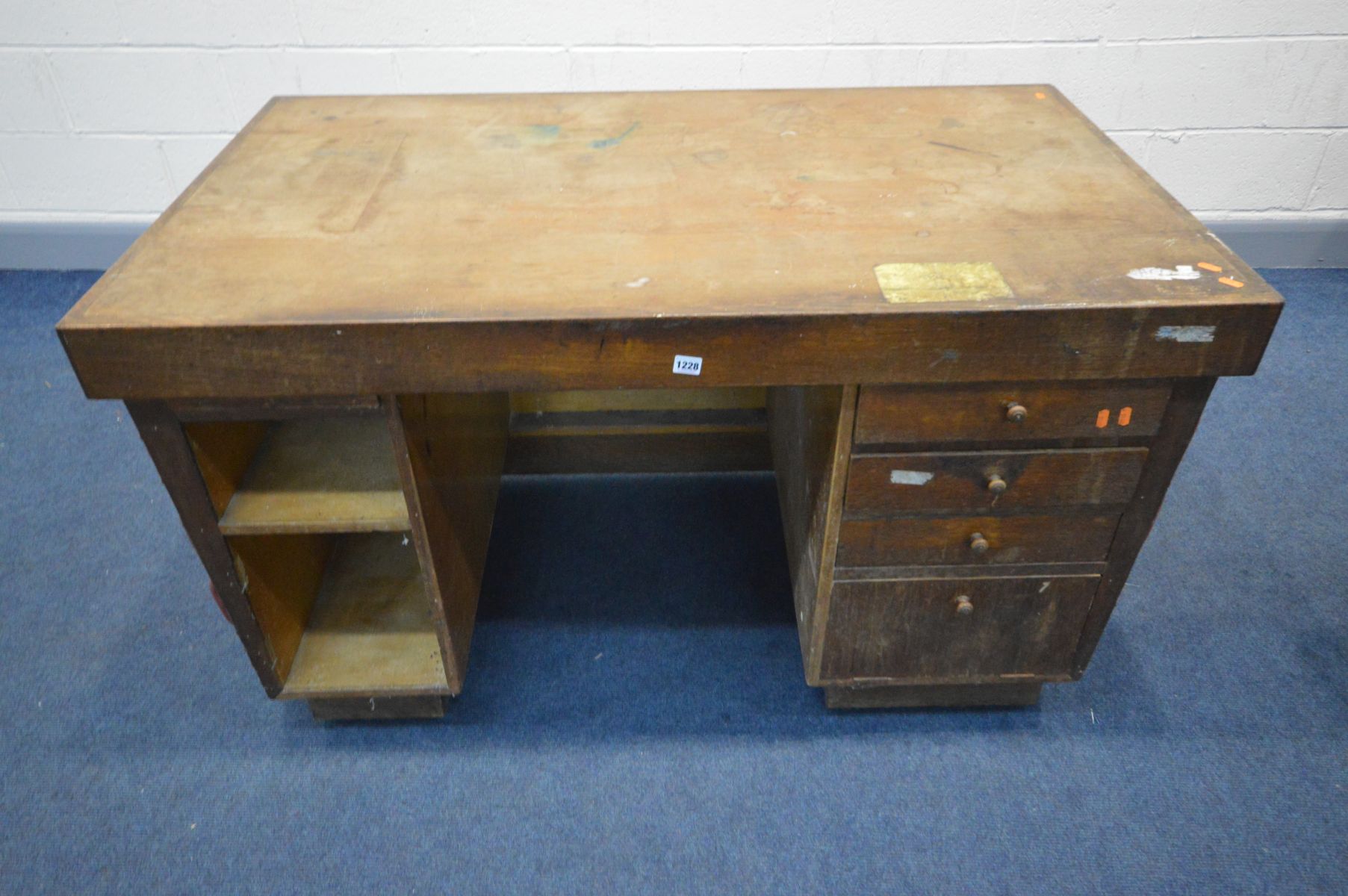 AN EARLY 20TH CENTURY OAK AND RED LEATHERETTE BUTTON SIDED KNEE HOLE DESK, with a bank of four