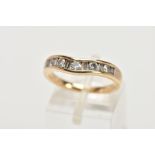 A YELLOW METAL DIAMOND HALF ETERNITY RING, of a wave design, channel set round brilliant cut