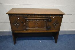 A REPRODUCTION JACOBEAN STYLE OAK SINGLE DOOR CREDENCE CABINET, on plank side supports united by a