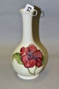 A MOORCROFT POTTERY ONION SHAPED VASE DECORATED WITH RED/BLUE HIBISCUS, cream ground, green