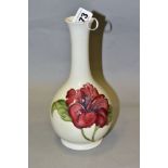 A MOORCROFT POTTERY ONION SHAPED VASE DECORATED WITH RED/BLUE HIBISCUS, cream ground, green