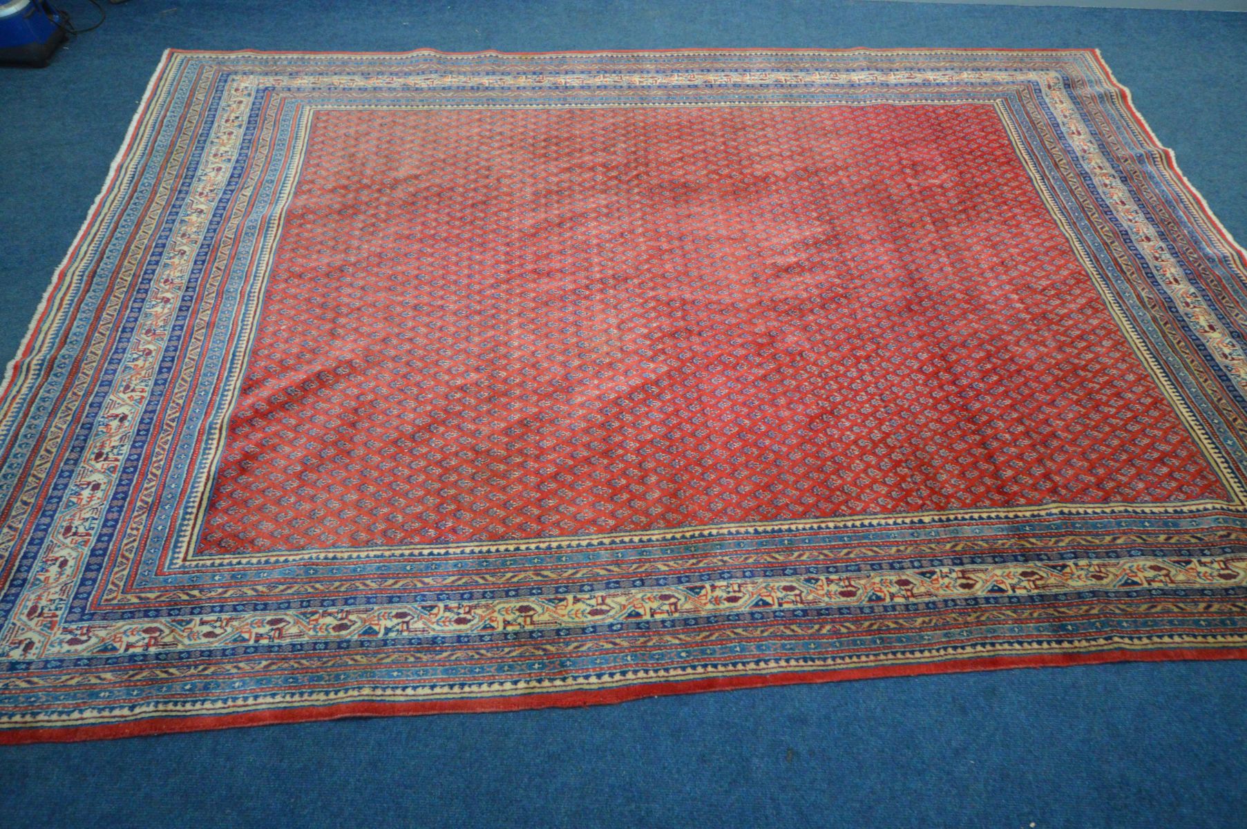 A RED GROUND WOOLEN RUG with a multistrap border, 360cm x 262cm (condition - overall good - Image 2 of 3