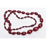 A CHERRY AMBER STYLE BAKELITE BEAD NECKLACE, graduated oval beads individually knotted on a red