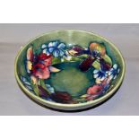 A MOORCROFT POTTERY FOOTED BOWL, in the Spring Flowers design, on a green/blue ground, painted
