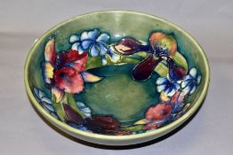 A MOORCROFT POTTERY FOOTED BOWL, in the Spring Flowers design, on a green/blue ground, painted