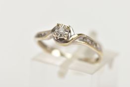 A 9CT WHITE GOLD DIAMOND RING, designed with an illusion set round brilliant cut diamond flanked