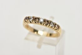 A YELLOW METAL DIAMOND HALF ETERNITY RING, designed with a row of claw set brown and white, round