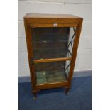 AN EARLY 20TH CENTURY OAK DISPLAY CABINET, the single glazed door enclosing three glass shelves,