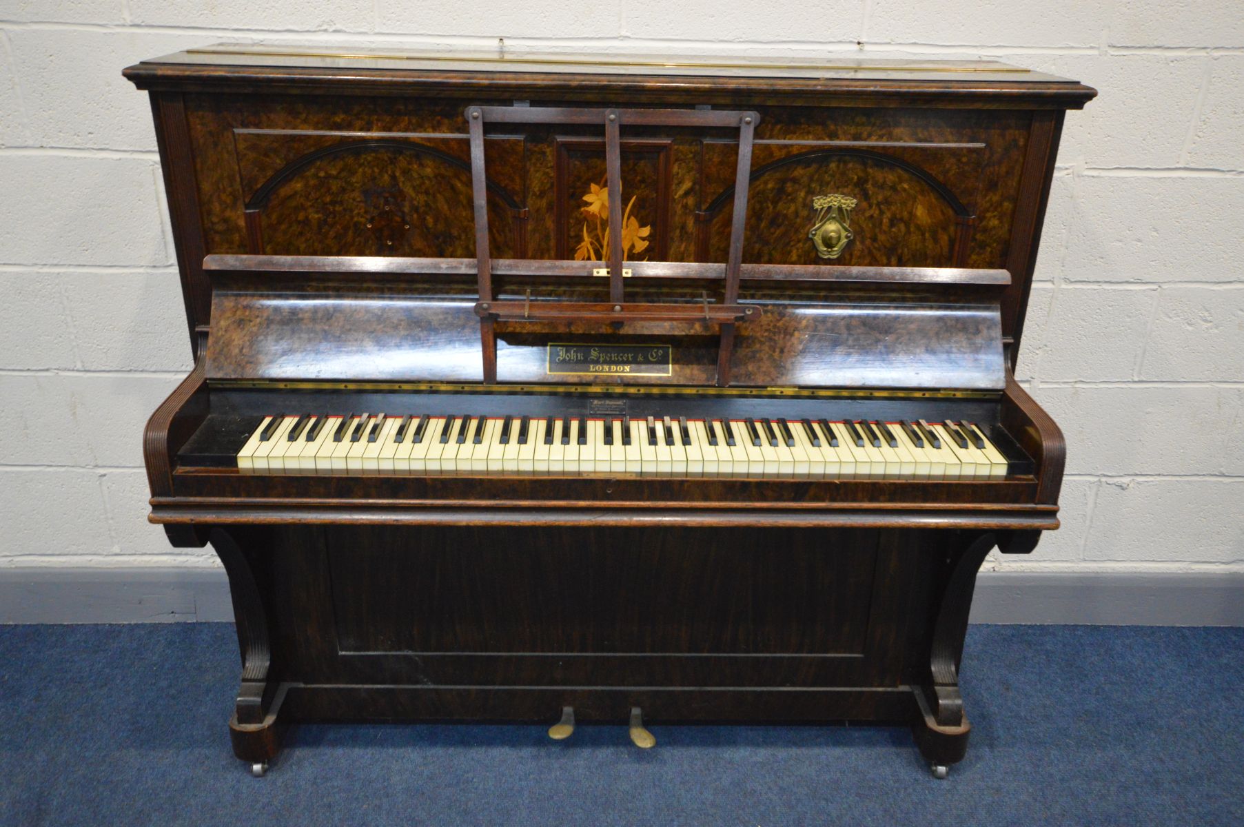JOHN AND SPENCER & CO, LONDON, an upright overstrung piano, with twin brass candle holders (loose