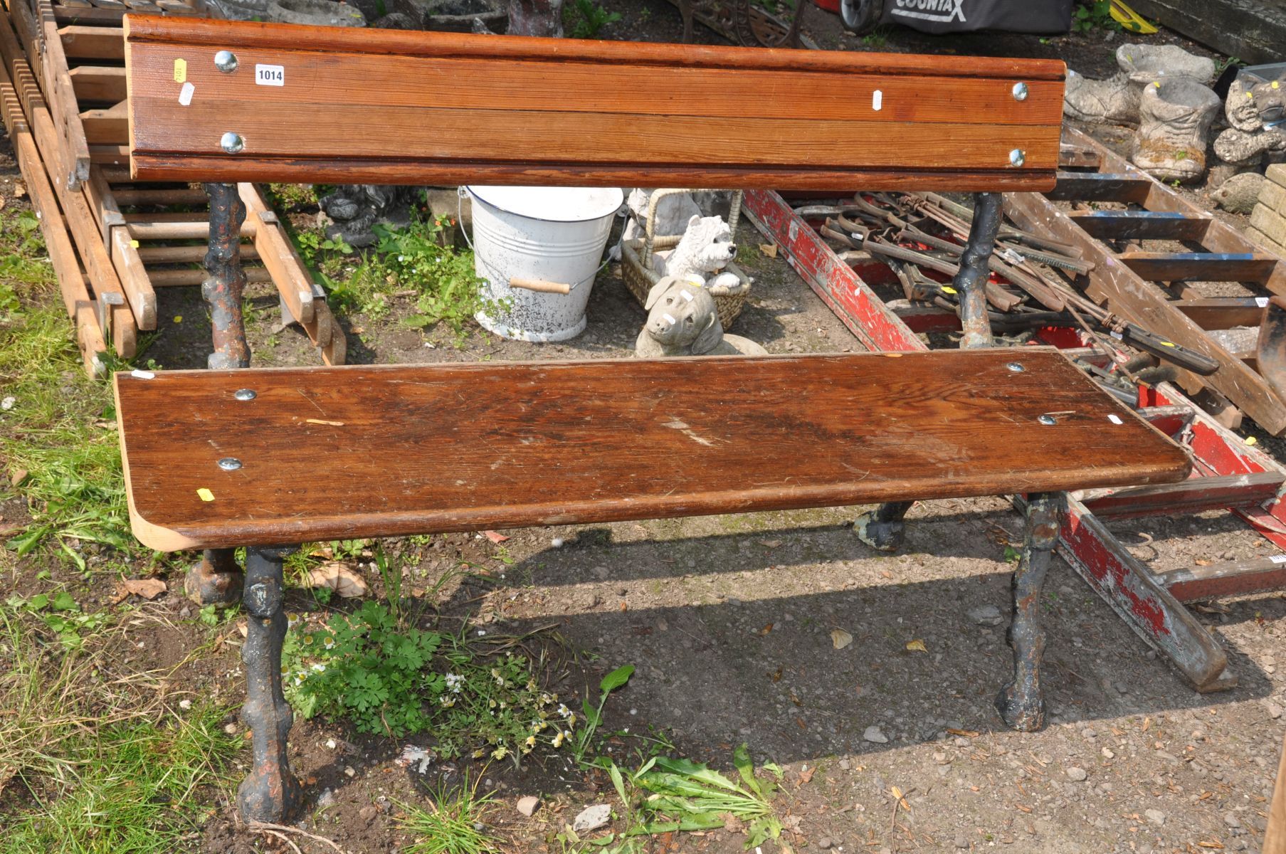 A CAST IRON GARDEN BENCH comprising of a pair of Victorian bench ends in the form of tree branches