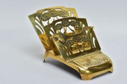 AN EARLY 20TH CENTURY ART NOUVEAU BRASS FOLDING LETTER RACK WITH FITTED INKWELL, pierced with