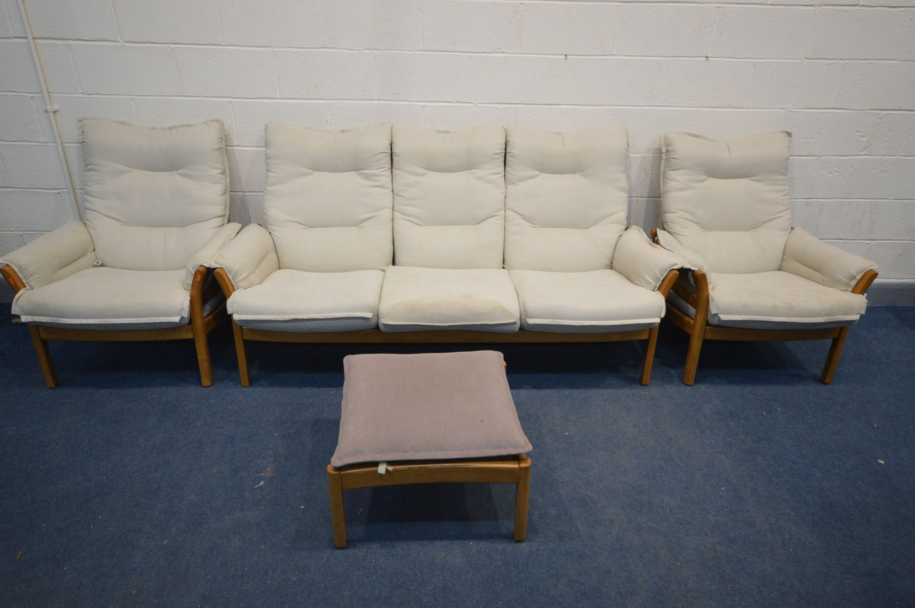 AN ERCOL GOLDEN DAWN ELM FOUR PIECE LOUNGE SUITE, comprising a three seater settee, pair of