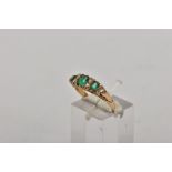 AN EARLY 20TH CENTURY GEM SET RING, designed with three-cushion cut green stones assessed as