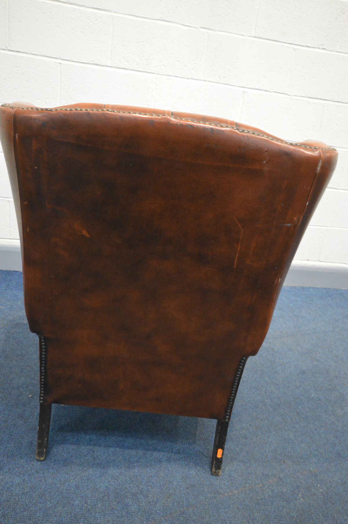 A BURNT ORANGE LEATHER BUTTON WINGBACK ARMCHAIR (condition - rip to left arm, crack to right arm, - Image 4 of 5