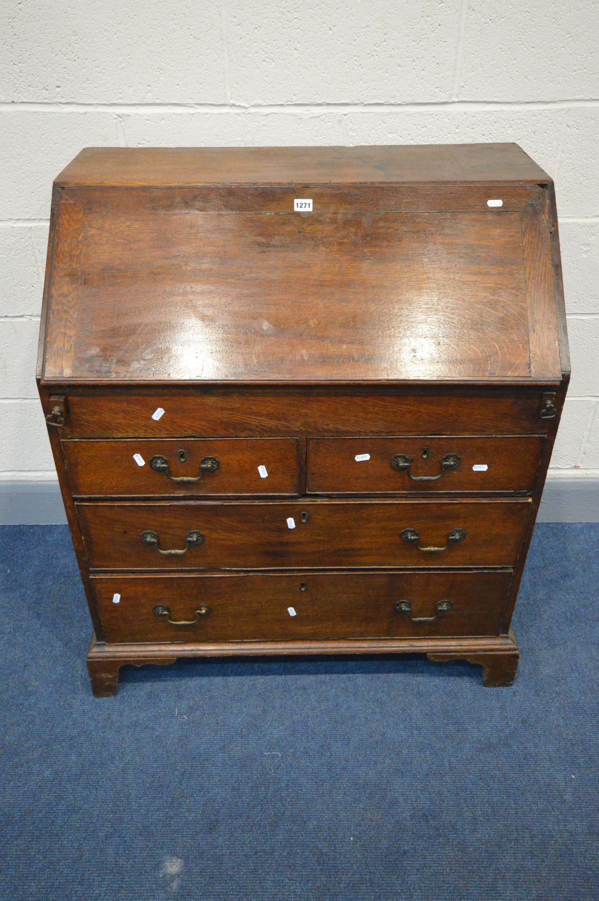 A GEORGIAN OAK BUREAU, the fall front enclosing a fitted interior, two short over two long