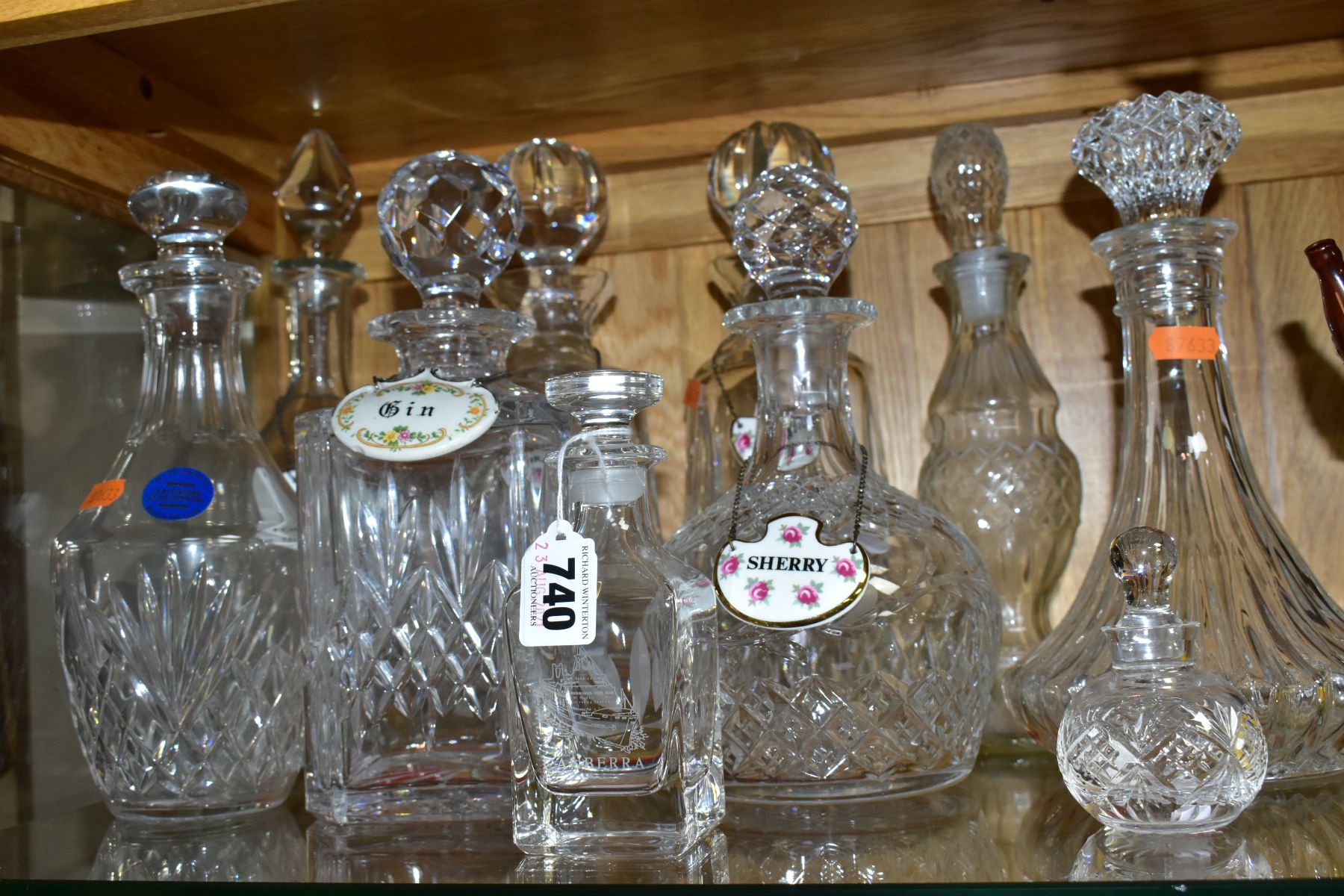 TEN CUT AND PRESSED GLASS DECANTERS AND BOTTLES, five with named porcelain decanter labels, one