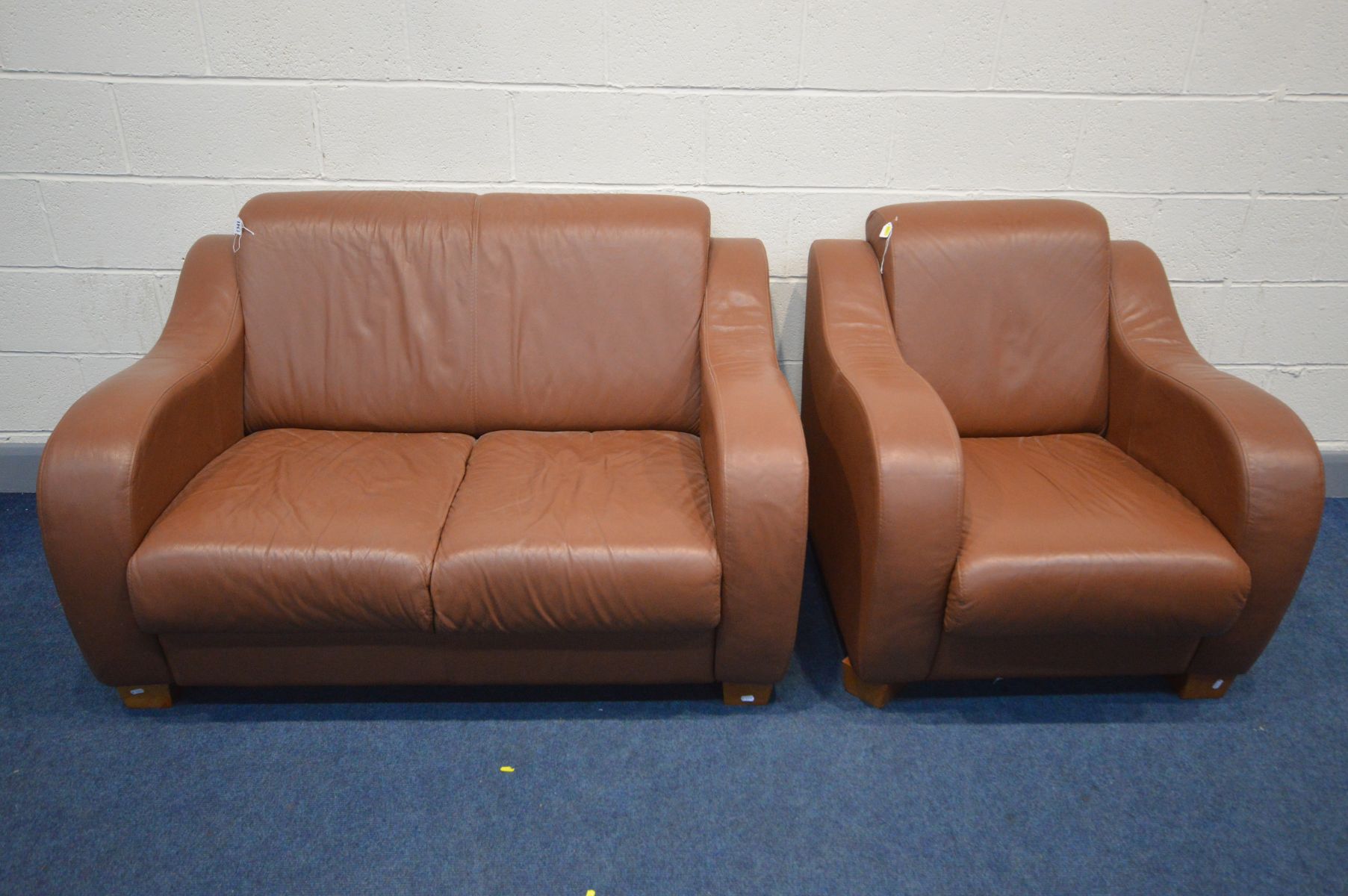 A BROWN LEATHER TWO PIECE LOUNGE SUITE, comprising a two seater settee and an armchair (2)