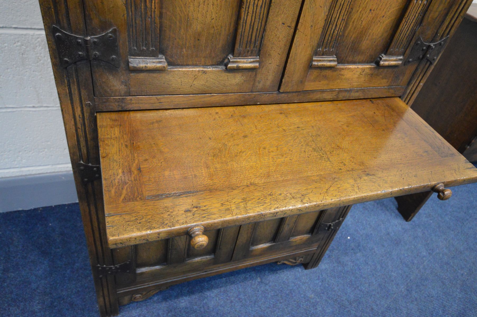 A REPRODUCTION OAK FOUR DOOR DRINKS CABINET, the arched panel door enclosing an arched shelf, and - Image 8 of 8