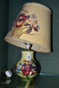 A MOORCROFT POTTERY SQUAT BALUSTER TABLE LAMP, in the Spring Flowers design, on pale yellow