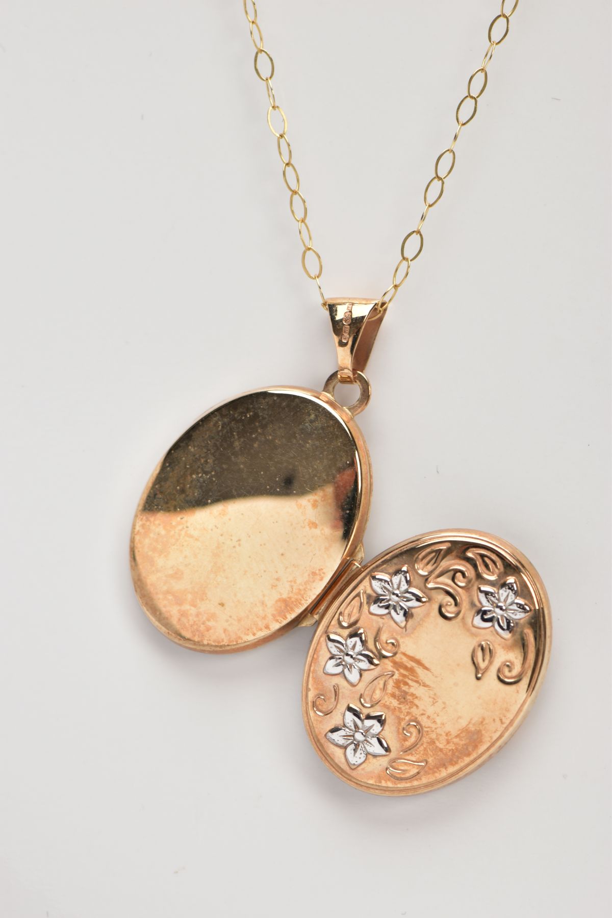 A 9CT GOLD LOCKET PENDANT NECKLACE, the locket of an oval form, decorated with white metal - Image 2 of 3