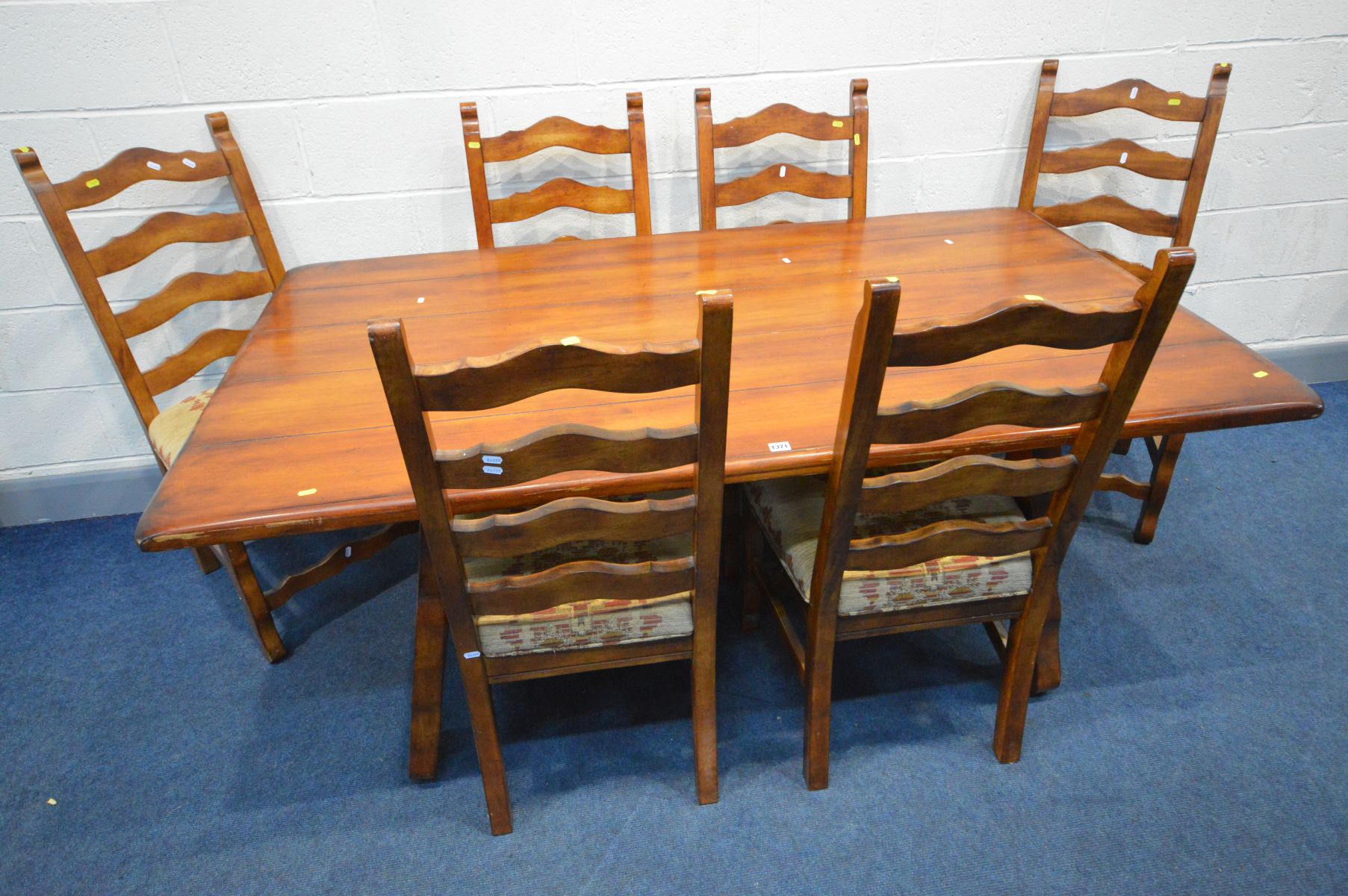 A THEODORE ALEXANDER STYLE FRUITWOOD REFRECTORY TABLE, on an ornate base united by metal stretchers,