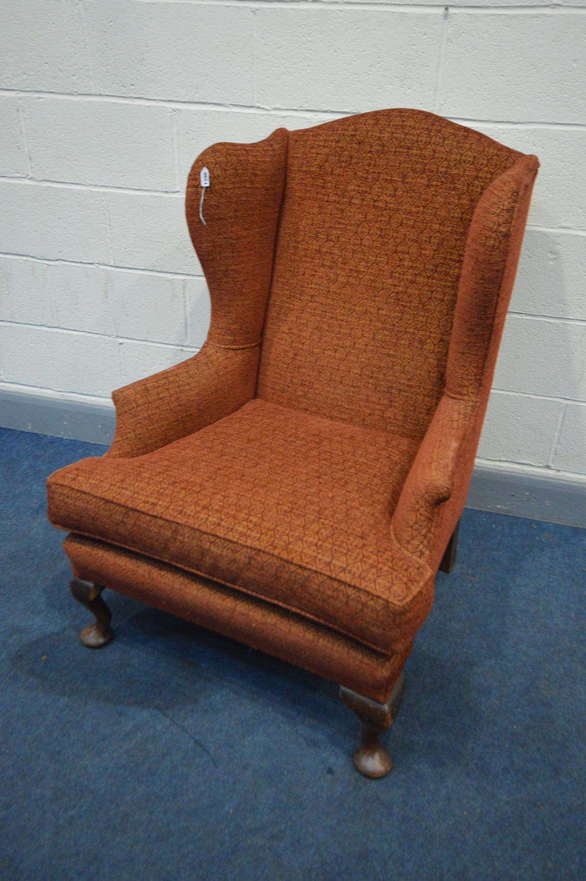 A GEORGIAN STYLE RED UPHOLSTERED WING BACK ARMCHAIR, on padded front feet, width 80cm x depth 92cm x