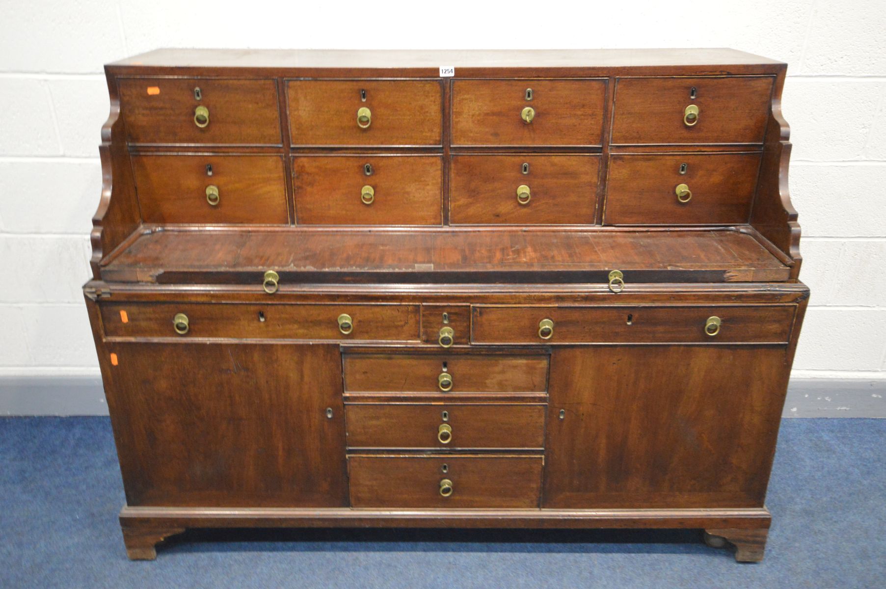 A GEORGIAN AND LATER MAHOGANY DESK, the top section with eight drawers and pull out writing slide,