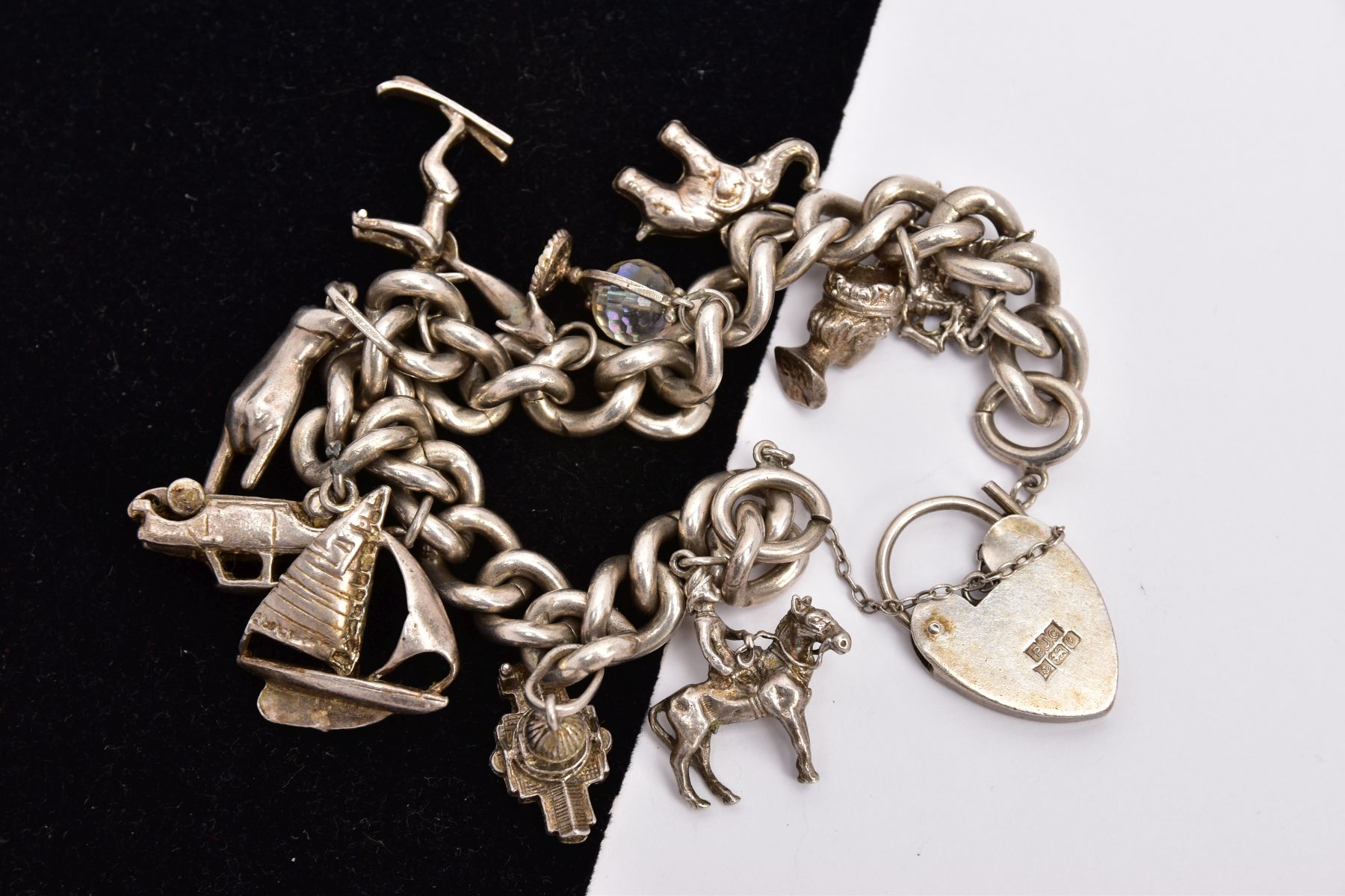 A SILVER CHARM BRACELET, the curb link bracelet suspending a total of eleven charms to include a - Image 2 of 2