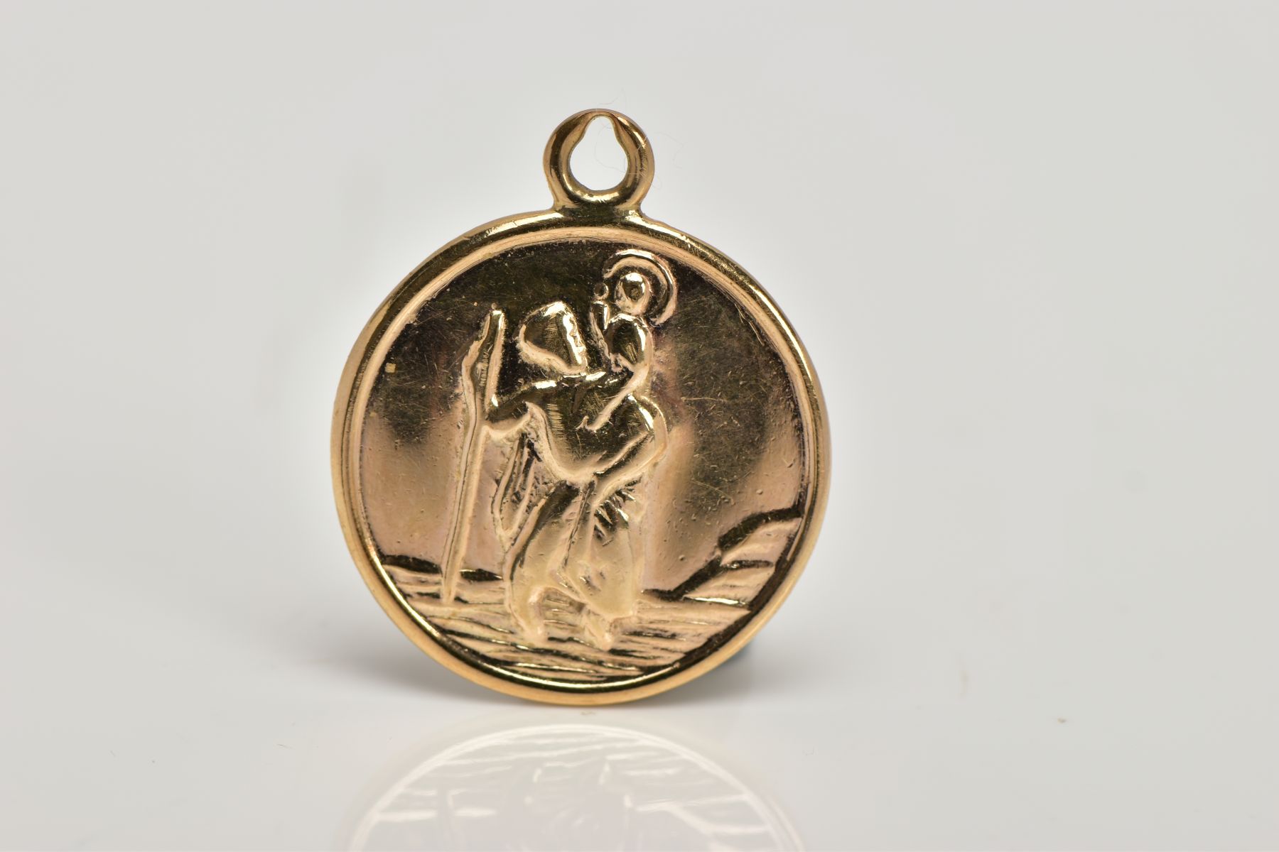 A 9CT GOLD ST. CHRISTOPHER PENDANT, of a circular form, approximate diameter 17.4mm, engraved