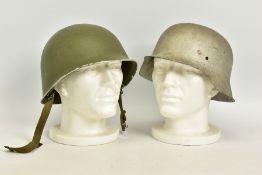 TWO MILITARY HELMETS to include a USA Pattern M1 helmet in Green, strap complete but no internal