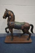 A HARDWOOD ROCKING HORSE raised on a plinth, length 90cm x height 98cm (condition - loose tail)