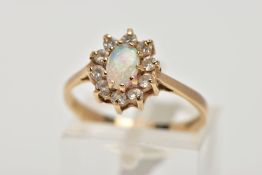 A 9CT GOLD OPAL CLUSTER RING, designed as a central oval opal cabochon within a circular cut cubic