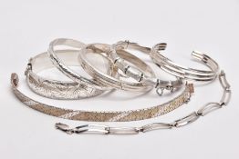 A PARCEL OF SILVER AND WHITE METAL BANGLES AND BRACELETS, to include a wide silver hinged bangle,