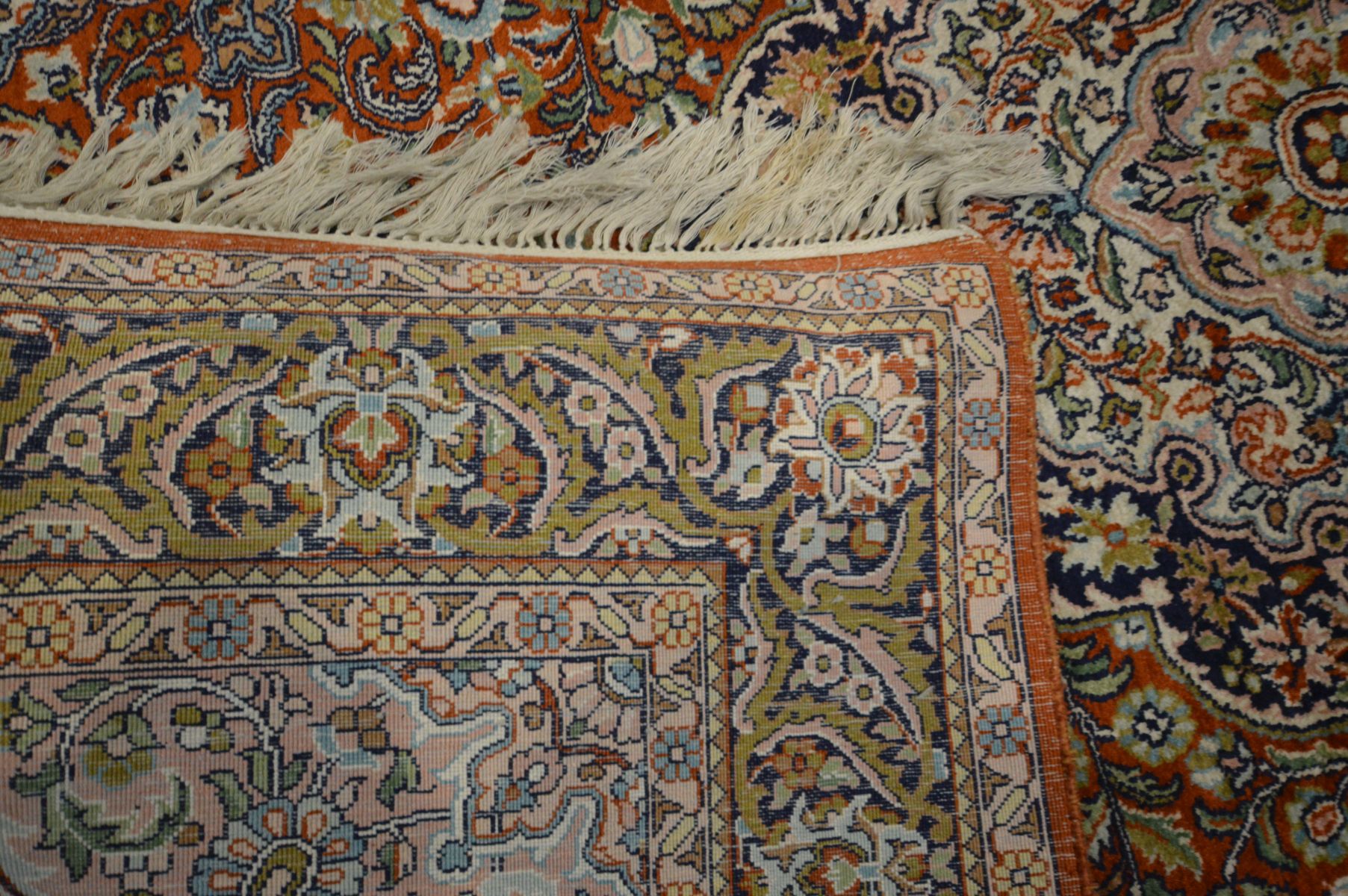 A KASHMIRI SILK RUG, scrolling foliate design on a red field, 182cm x 125cm, a woollen cream - Image 4 of 6