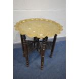 AN ANGLO-INDIAN BRASS TOP TABLE, depicting the Taj Mahal, on a folding Moorish style base,