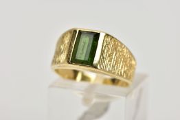 A YELLOW METAL TOURMALINE RING, designed with a rectangular cut green tourmaline, textured