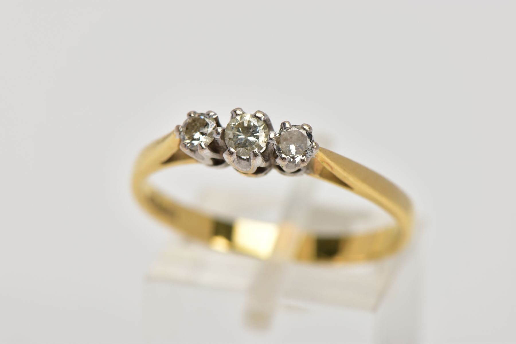 AN 18CT GOLD THREE STONE DIAMOND RING, designed with a row of three graduated round brilliant cut