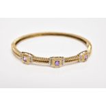 A 9CT GOLD AMETHYST AND DIAMOND HINGED BANGLE, the bangle with a twist pattern, set with three