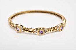 A 9CT GOLD AMETHYST AND DIAMOND HINGED BANGLE, the bangle with a twist pattern, set with three